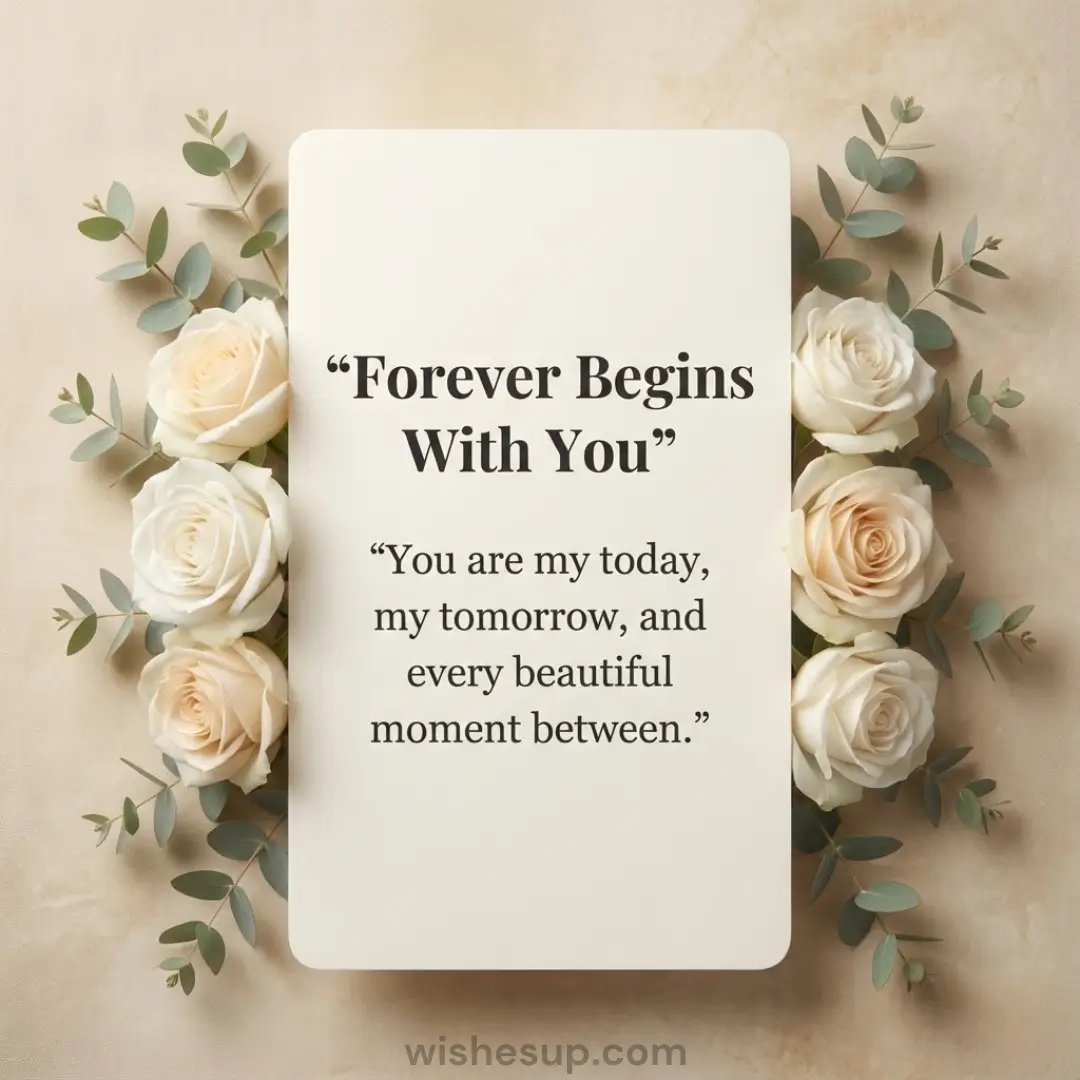An ivory card inscribed with "Forever Begins With You" is framed by velvety white roses and silvery-green eucalyptus. Soft, diffused light illuminates the scene against a textured beige backdrop, creating a serene and timeless atmosphere.