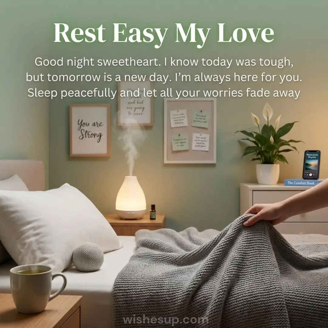 A hand pulls a textured grey blanket in a cozy bedroom with sage green walls and warm lighting. A glowing diffuser releases a gentle mist near a steaming mug, framed by a lush peace lily and supportive wall art.